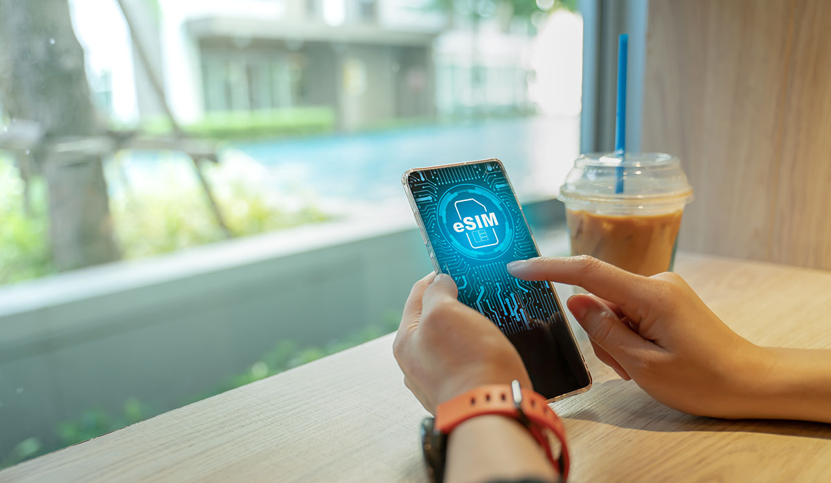 Close up of Woman using a phone with eSIM technology. Mobile dev digital nomad eSIM