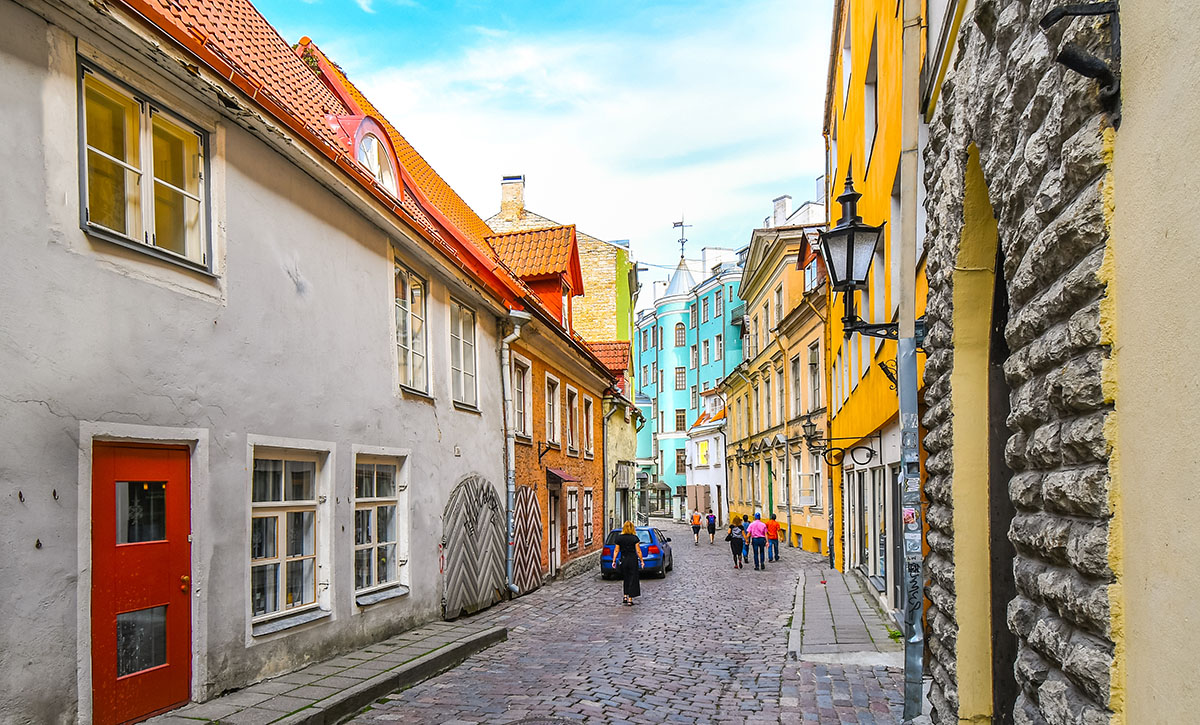 Tourists walk down a picturesque cobblestone street in a residen Estonia's Digital Nomad