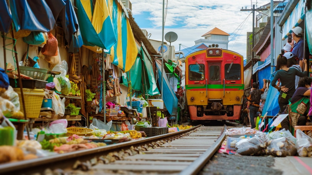 Maeklong,Railway,Market,Thailand,,Train,On,Tracks,Moving,Slow.,Umbrella Thailand for Digital Nomads